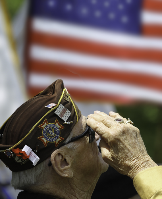 Veteran saluting American flag.